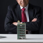 マンションと悩む男性