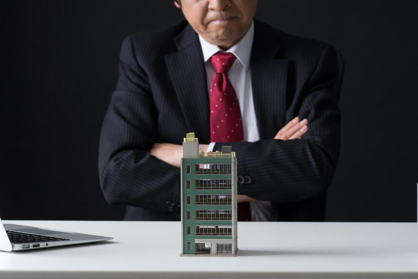 マンションと悩む男性